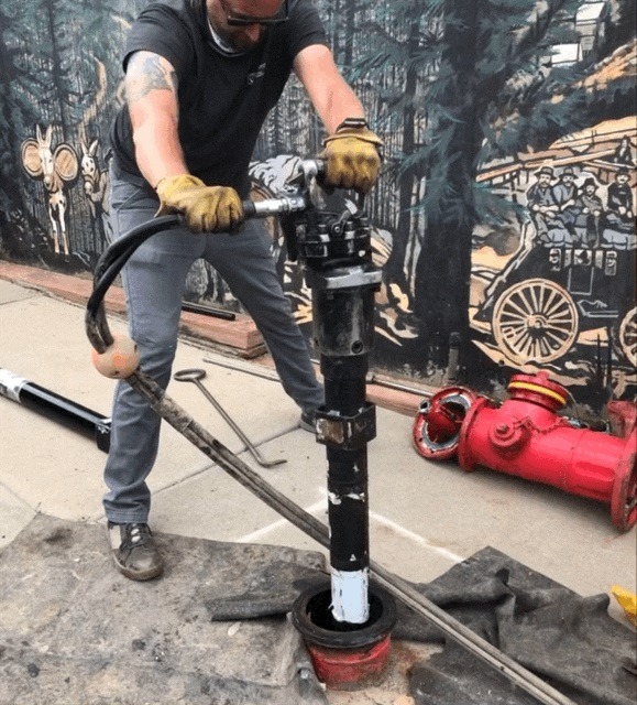 IW-24 Hydrant Saver in field use — utility worker operating tool on fire hydrant
