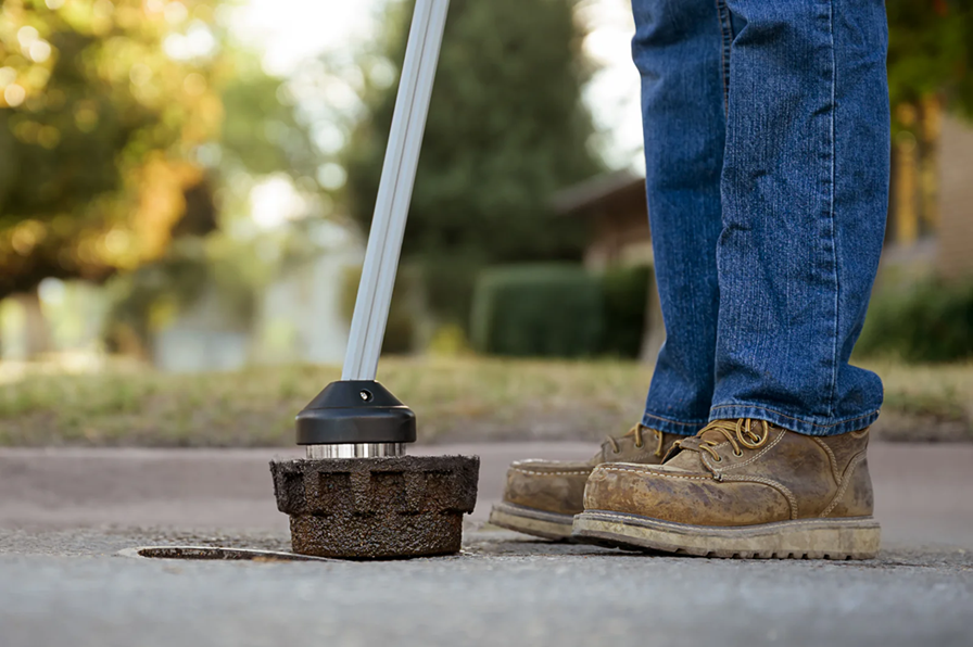 EZLyft magnetic head attached to water valve cover — close-up ground level view showing magnet connection