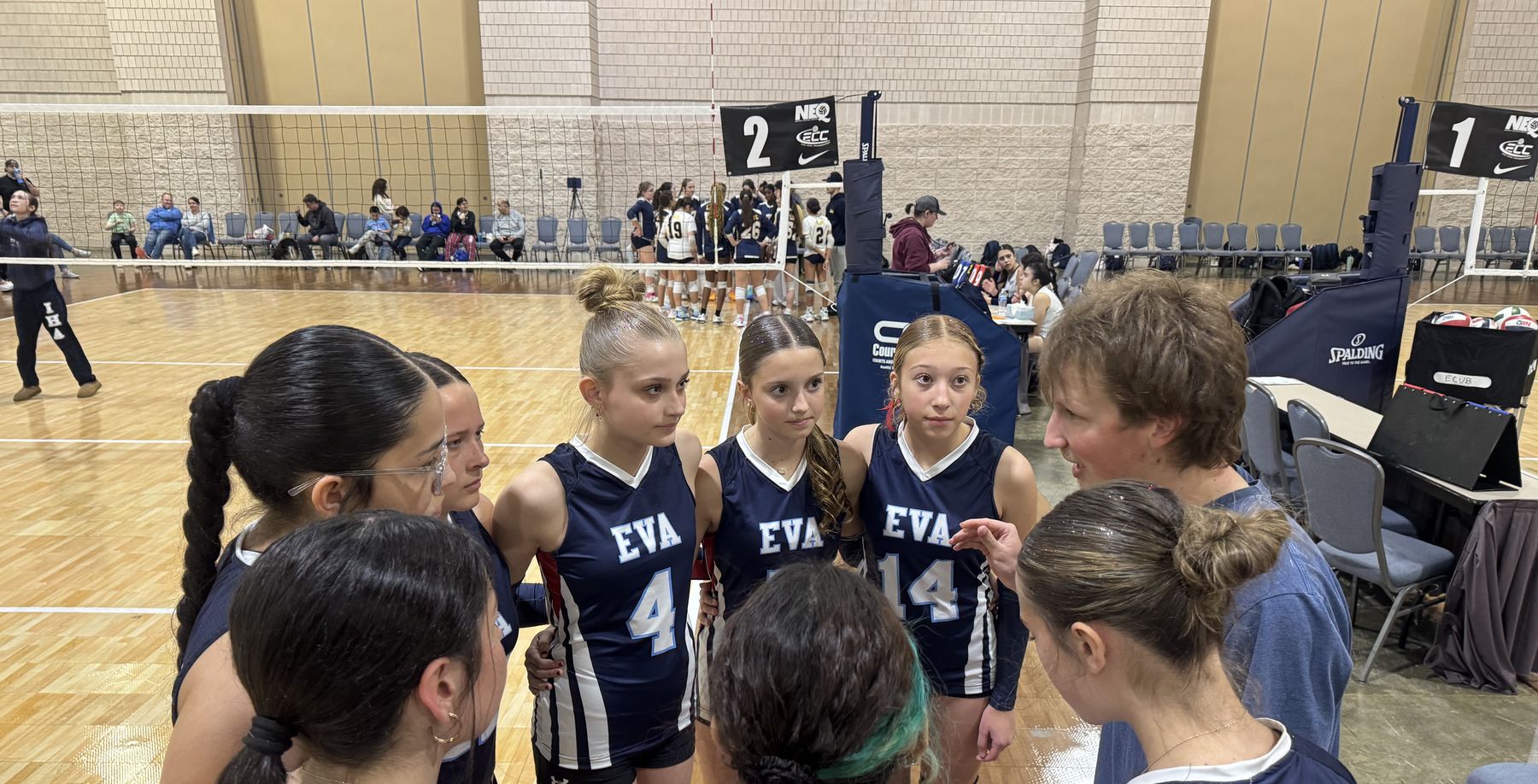 An EVA coach talks with players during a timeout at a tournament