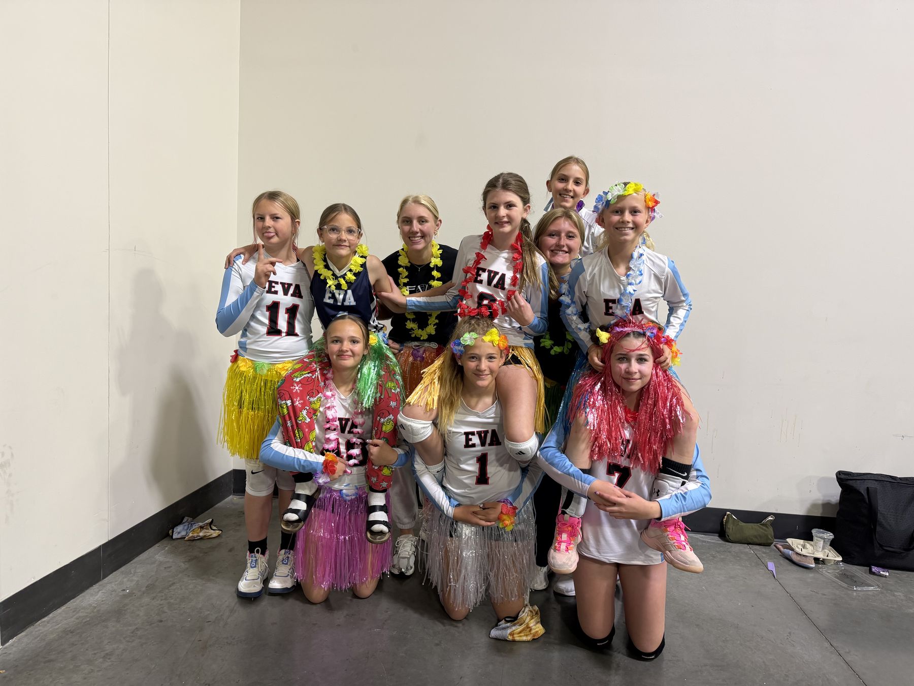 EVA players in leis and grass skirts having fun together